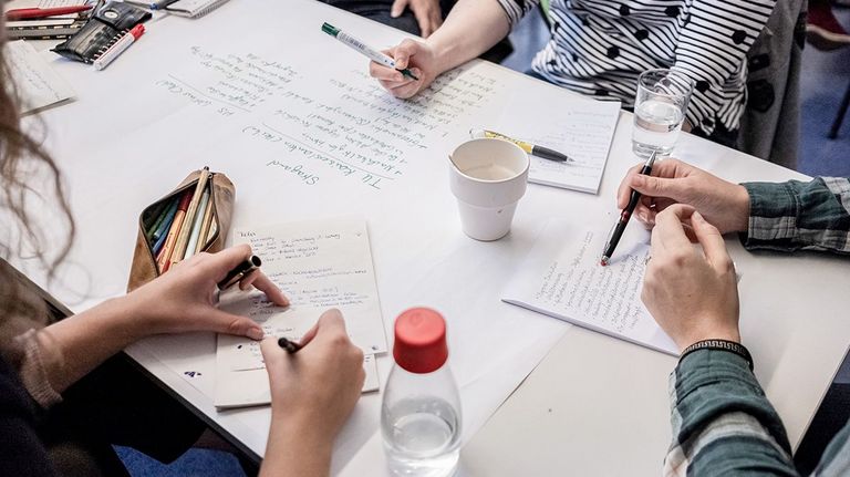Personen am Tisch, gemeinsames Lernen