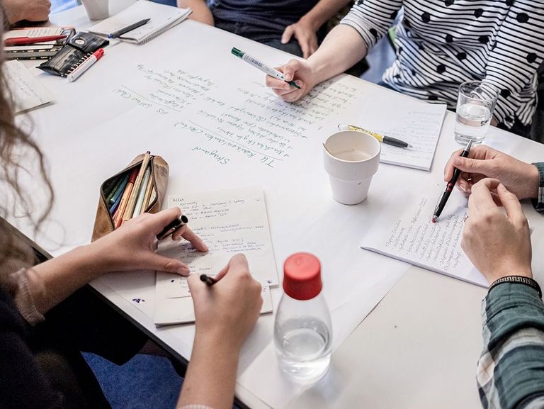 Personen am Tisch, gemeinsames Lernen