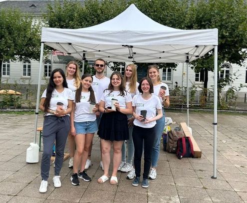 Gruppe Studierender unter Pavillon auf einem öffentlichen Platz in Wiesbaden.