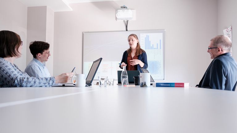 [Translate to Englisch:] Titelfoto Umwelt- und Wirtschaftsinformatik (dual): Duale Studentin bei Präsentation im Ausbildungsbetrieb.