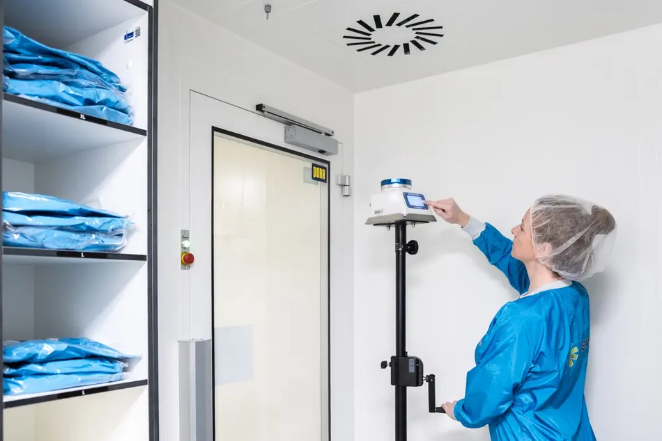 Studentin arbeitet in der Reinraumschleuse mit Messgerät (Luftkeimsammler).