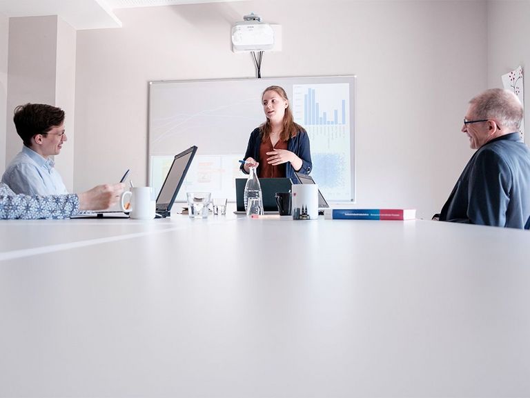 Person präsentiert vor kleiner Gruppe