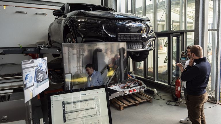 Auto auf Hebebühne, Bildschirm mit Daten daneben