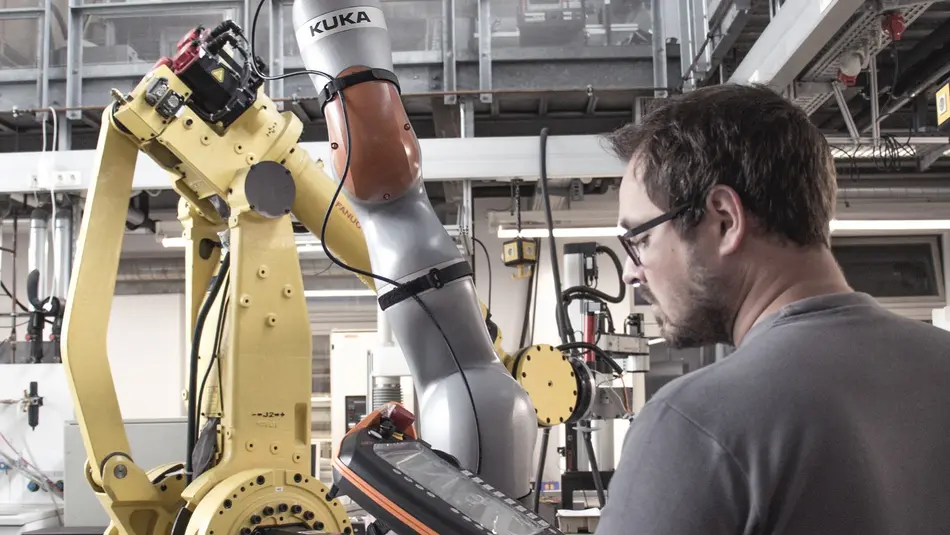 Mitarbeiter der Robotix Academy am Roboter