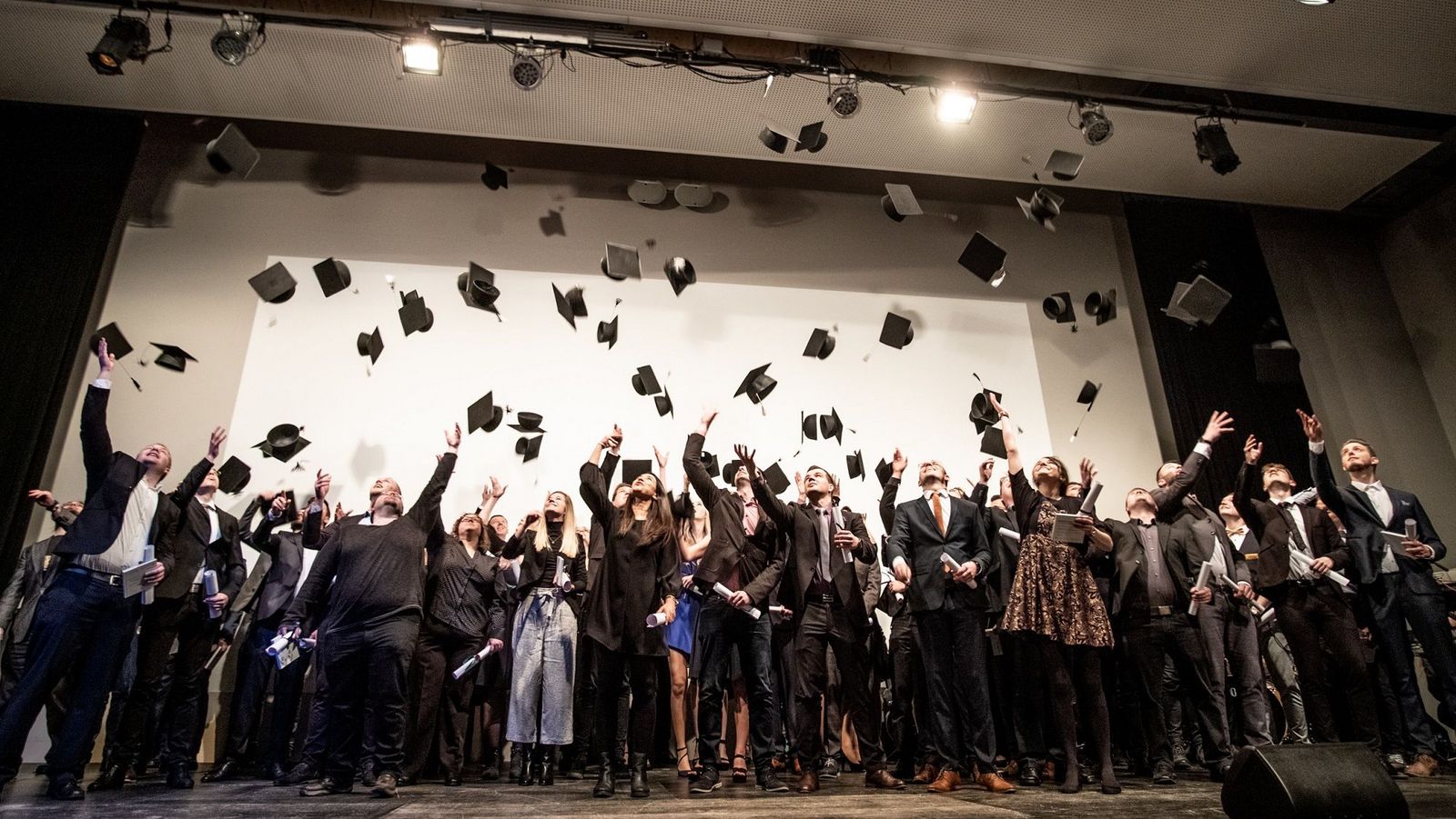 Graduates toss hats at graduation in 2020