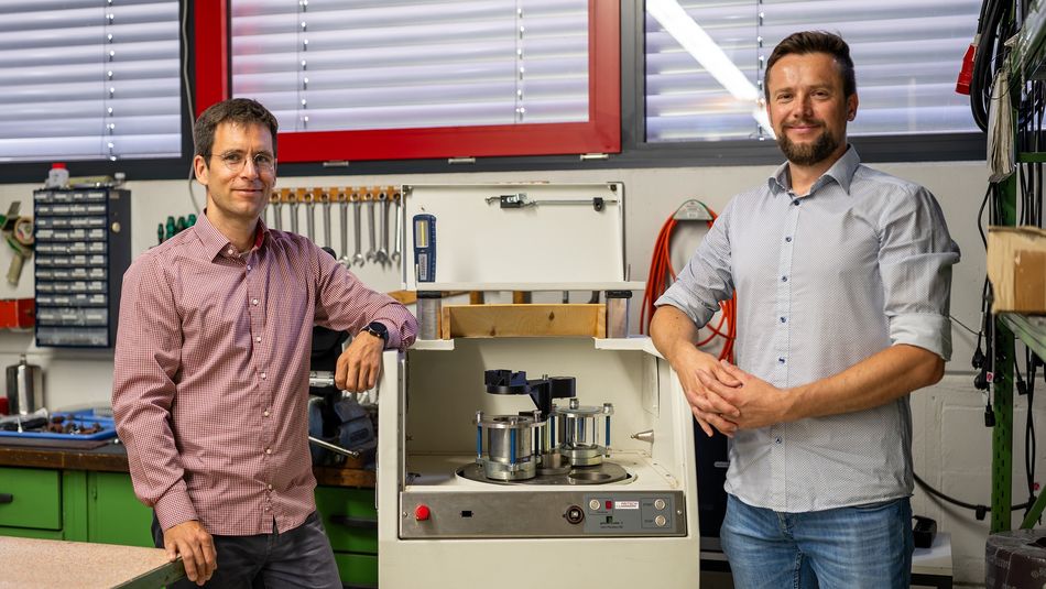 Tandem-Professor Lukas Lentz (links) und Wjatscheslaw Oshereljew, B.Sc. (rechts), in der Werkstatt der Firma Fritsch vor einem Experiment, das sie gemeinsam betreuen.